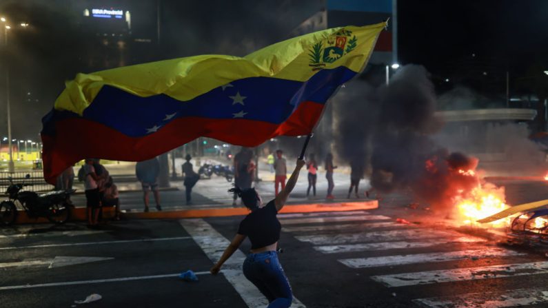 Une manifestante brandit un drapeau vénézuélien lors d'une manifestation contre les résultats officiels de l'élection présidentielle, le 29 juillet 2024 à Caracas, au Venezuela. (Jesus Vargas/Getty Images)