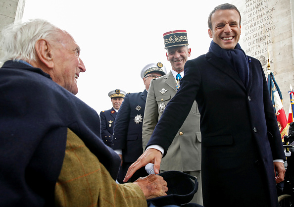 Emmanuel Macron (à dr.) salue le vétéran Jacques Lewis (à g.) lors d'une cérémonie marquant le 74e anniversaire de la victoire de la Seconde Guerre mondiale en Europe à l'Arc de Triomphe à Paris, le 8 mai 2019. (CHRISTIAN HARTMANN/AFP via Getty Images)