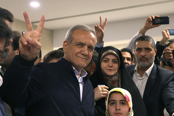 Le réformateur Massoud Pezeshkian brandit le signe V de la victoire après avoir voté lors de l'élection présidentielle à Téhéran, le 28 juin 2024. (ATTA KENARE/AFP via Getty Images)