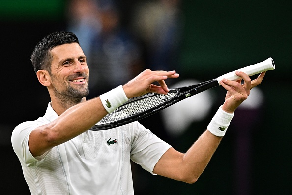 Le Serbe Novak Djokovic fait semblant de jouer du violon pour sa fille comme célèbration de sa victoire contre le Danois Holger Rune à Wimbledon, le 8 juillet 2024. (Photo ANDREJ ISAKOVIC/AFP via Getty Images)