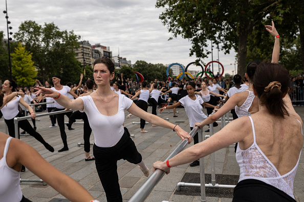 Des danseurs participent à un cours de ballet en plein air dans le cadre du relais de la flamme olympique sur la place de la Bastille le 14 juillet 2024. (OLYMPIA DE MAISMONT/AFP via Getty Images)