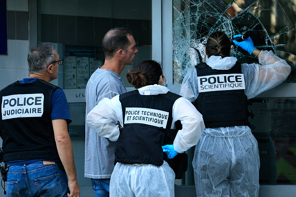 Des agents de la police scientifique inspectent le bâtiment touché par un incendie criminel, à Nice le 18 juillet 2024. (Photo VALERY HACHE/AFP via Getty Images)