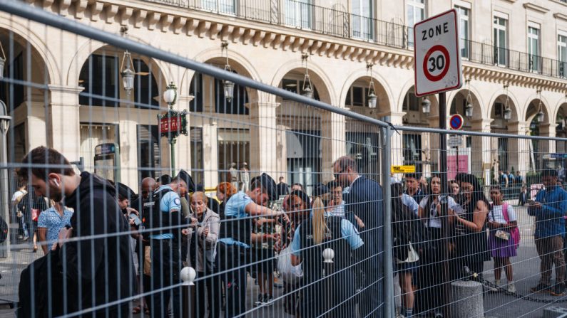 Des officiers de la gendarmerie française vérifient les codes QR et les bagages des piétons à un point de contrôle des barrières pour circuler près du Musée du Louvre à Paris le 18 juillet 2024, avant la cérémonie d'ouverture des Jeux olympiques de Paris 2024. (Crédit photo DIMITAR DILKOFF/AFP via Getty Images)