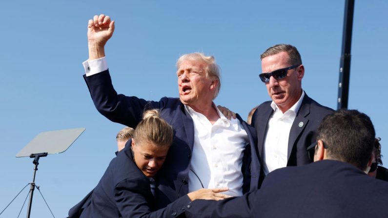 Le candidat républicain à la présidence, l'ancien président Donald Trump, est évacué de la scène lors d'un meeting le 13 juillet 2024 à Butler, en Pennsylvanie. (Anna Moneymaker/Getty Images)