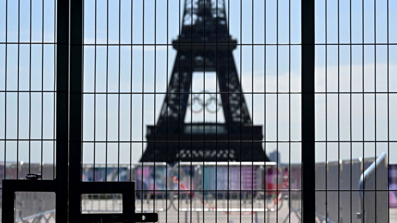 La Tour Eiffel vue à travers une clôture, avant les Jeux Olympiques et Paralympiques de Paris 2024, à Paris, le 19 juillet 2024. (GABRIEL BOUYS/AFP via Getty Images)