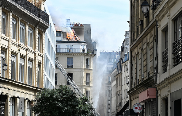 Le toit d'un immeuble résidentiel en feu, à Paris, le 20 juillet 2024. (STEFANO RELLANDINI/AFP via Getty Images)