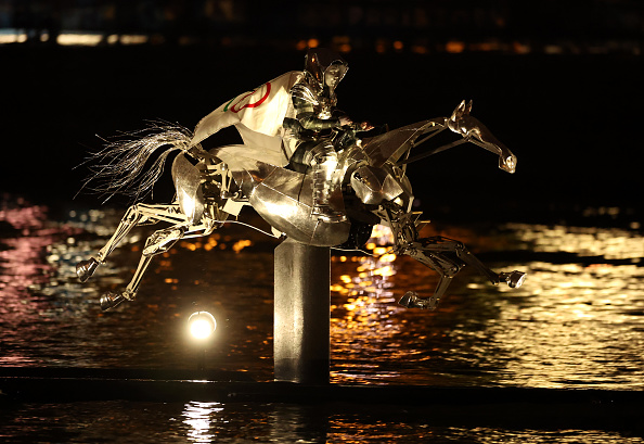 La cavalière, portant le drapeau du Comité international olympique (CIO), monte un cheval de métal sur la Seine lors de la cérémonie d'ouverture des Jeux olympiques Paris 2024 le 26 juillet 2024.  (Richard Pelham/Getty Images)