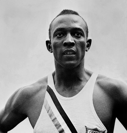 Le champion américain "Jesse" (James Cleveland) Owens lors des Jeux olympiques de Berlin, en août 1936, où il remporte 4 médailles d'or, 100m, 200m, 4x100m et saut en longueur. (Photo par -/AFP via Getty Images)