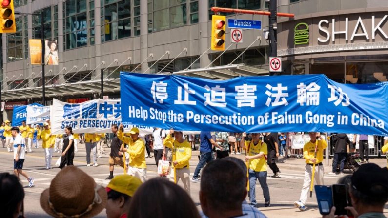 Des pratiquants du Falun Gong participent à un défilé dans le centre de Toronto le 20 juillet 2024, marquant le 25e anniversaire de la persécution de la pratique spirituelle par le régime chinois. (Evan Ning/Epoch Times)