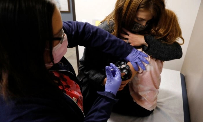 Une enfant de 6 ans est réconfortée par sa mère alors qu'elle reçoit sa première dose du vaccin Pfizer-BioNTech contre le Covid-19 à Novi, Michigan. (Jeff Kowalsky/AFP via Getty Images)