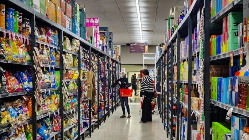 Des gens font leurs courses dans le rayon confiserie d'un supermarché.(Susan Mortimer/Epoch Times)