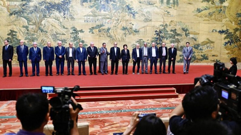 Le ministre chinois des Affaires étrangères, Wang Yi (au c.), pose pour une photo de groupe avec des membres des factions palestiniennes lors de la signature de la "déclaration de Pékin" à la maison d'hôtes d'État Diaoyutai à Pékin, le 23 juillet 2024. (PEDRO PARDO/POOL/AFP via Getty Images)