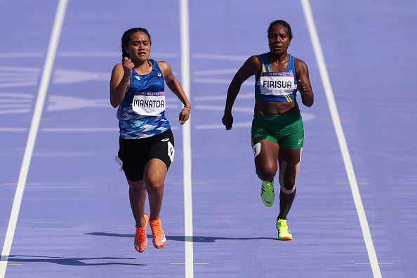 Sharon Firisua (à dr.) de l'équipe des Îles Salomon participe au tour préliminaire du 100m féminin lors de la septième journée des JO-2024, le 02 août 2024 à Paris. (Steph Chambers/Getty Images)