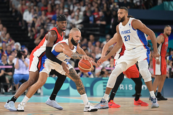 Le Français #10 Evan Fournier (2e à g.) contourne le Canadien #02 Shai Gilgeous-Alexander (à g.) lors du quart de finale de basket-ball entre la France et le Canada, le 6 août 2024. (DAMIEN MEYER/AFP via Getty Images)