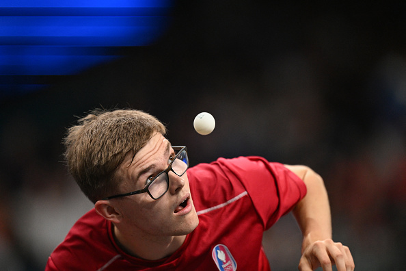 Alexis Lebrun regarde la balle pendant son match de tennis de table masculin en simple lors des quarts de finale par équipes entre le Brésil et la France. (JUNG YEON-JE/AFP via Getty Images)