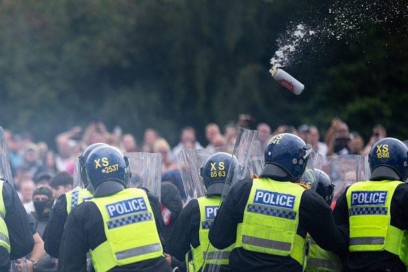 Des policiers anti-émeutes repoussent des manifestants anti- immigration devant l'hôtel Holiday Inn Express qui héberge des demandeurs d'asile, le 4 août 2024 à Rotherham, au Royaume-Uni. (Christopher Furlong/Getty Images)