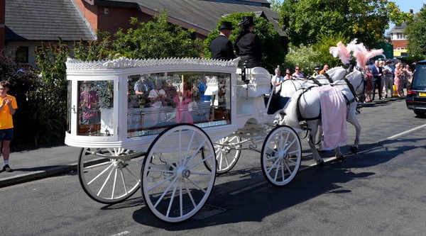 Le petit cercueil blanc transportant la dépouille d'Alice da Silva Aguiar dans un carrosse tiré par deux chevaux blancs arrive à l'église catholique St Patrick, le 11 août 2024 à Southport, en Angleterre. (Photo par Christopher Furlong/Getty Images)