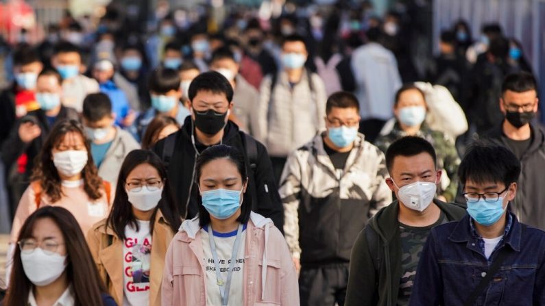 Des usagers de transport collectif portent des masques de protection alors qu'ils sortent d'une rame dans une station de métro à l'heure de pointe à Pékin, en Chine, le 13 avril 2020. (Lintao Zhang/Getty Images)