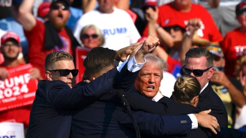 Le candidat républicain à la présidence, l'ancien président Donald Trump, est emmené par les services secrets après que des coups de feu ont retenti lors d'un rassemblement de campagne à Butler Farm Show Inc. à Butler, en Pennsylvanie, le 13 juillet 2024. (Jeff Swensen/Getty Images)