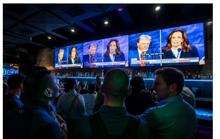 Des gens regardent le débat présidentiel entre la vice-présidente Kamala Harris et l'ancien président Donald Trump, au bar et salon Slate à New York, le 10 septembre 2024. (Samira Bouaou/Epoch Times)