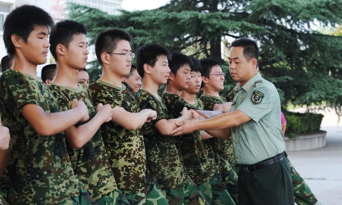 Des étudiants s'entraînent à marcher sous la direction d'un soldat de l'Armée populaire de libération lors de la première semaine de service militaire au lycée dans une base à Hefei, dans la province orientale de l'Anhui, le 5 août 2010. (AFP/Getty Images)