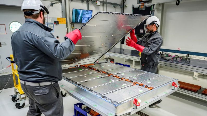 
Des ouvriers ouvrent un pack de batterie, révélant les modules de la batterie, dans l'usine pilote de recyclage de Volkswagen pour les cellules de batteries de voitures à l'usine de composants VW à Salzgitter, dans le centre-nord de l'Allemagne, le 18 mai 2022. (JOHN MACDOUGALL/AFP via Getty Images)