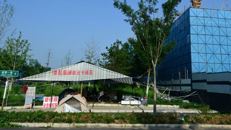 Des personnes manifestent à côté d'un projet immobilier du promoteur Country Garden à Pékin, le 15 août 2023. (PEDRO PARDO/AFP via Getty Images)