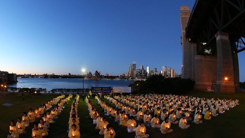 Des pratiquants du Falun Gong tiennent des bougies lors d'une veillée marquant l'anniversaire du début de la persécution du Falun Gong en Chine, le 21 juillet 2013 à Sydney, en Australie. (Brendon Thorne/Getty Images)