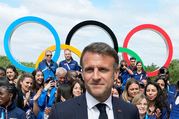 Emmanuel Macron avec des athlètes français lors d'une visite au village olympique, à Saint-Denis en juillet 2024. (MICHEL EULER/POOL/AFP via Getty Images)