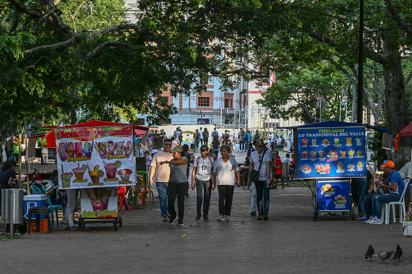 Des personnes marchent dans une rue de Cali, province de Valle del Cauca, Colombie, le 22 juillet 2024. Le sommet COP16 sur la biodiversité, qui se tiendra entre octobre et novembre dans la ville colombienne de Cali, bénéficiera de « toutes les garanties de sécurité », ont promis les organisateurs le 17 juillet. Les dissidents de la guérilla des FARC, aujourd'hui disparue, ont menacé d'empêcher la tenue de l'événement. (Photo by JOAQUIN SARMIENTO/AFP via Getty Images)