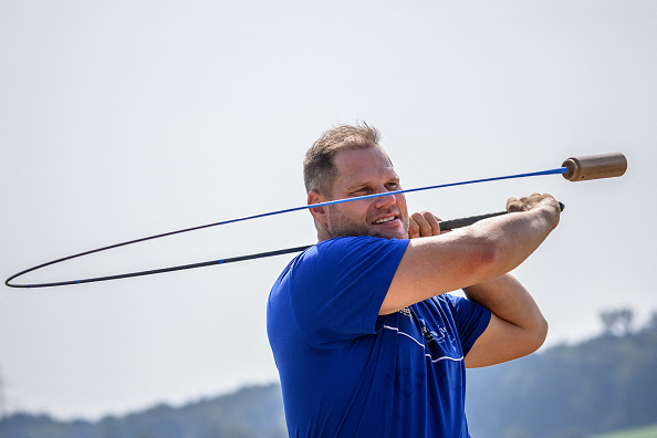 Le hornusser Stefan Studer pendant un match de hornuss lors du 40e festival suisse de hornussen, le 31 août 2024 à Hoechstetten. (FABRICE COFFRINI/AFP via Getty Images)