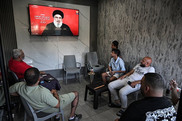 Des personnes assistent à un discours télévisé du chef du mouvement terroriste chiite libanais Hezbollah Hassan Nasrallah depuis un café situé à l'entrée du camp de Sabra pour les réfugiés palestiniens dans la banlieue sud de Beyrouth, le 19 septembre 2024. (Photo JOSEPH EID/AFP via Getty Images)