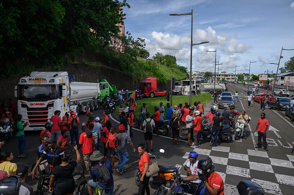 Des passants et des manifestants soutiennent les chauffeurs de camion qui participent à un convoi de protestation tentant d'atteindre la préfecture à Fort-de-France, le 24 septembre 2024. (ED JONES/AFP via Getty Images)