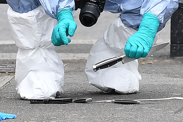 Un policier scientifique britannique tient un couteau comme preuve sur les lieux où un homme a été arrêté et emmené par la police en 2017. Illustration. (JUSTIN TALLIS/AFP via Getty Images)