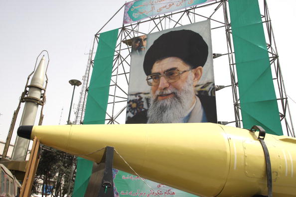 Des missiles iraniens Shahab-2 (à g.) et Shahab-3 sont exposés devant un grand portrait du guide suprême iranien, l'ayatollah Ali Khamenei, à Téhéran, le 28 septembre 2008. (Photo ATTA KENARE/AFP via Getty Images)