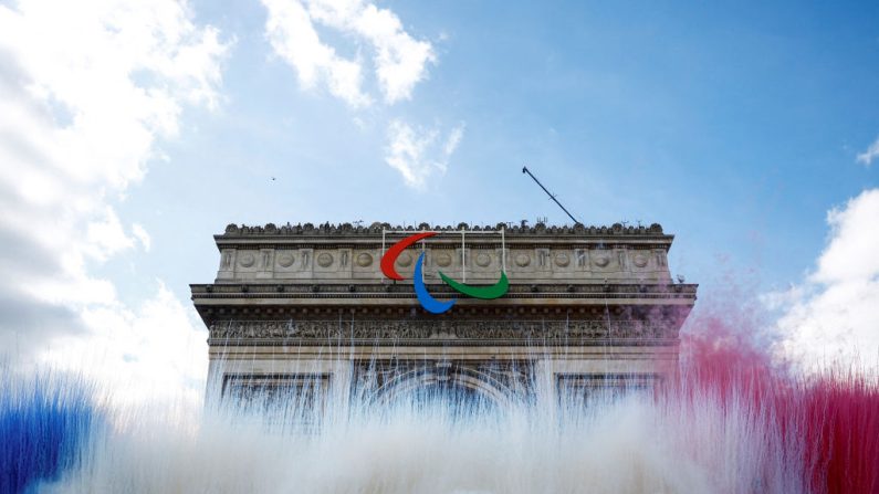 Des fumigènes aux couleurs du drapeau national français s'élèvent devant l'Arc de Triomphe lors du défilé des athlètes français qui ont participé aux Jeux olympiques et paralympiques de Paris 2024, à Paris, le 14 septembre 2024. (Sarah Meyssonnier/POOL/AFP via Getty Images)