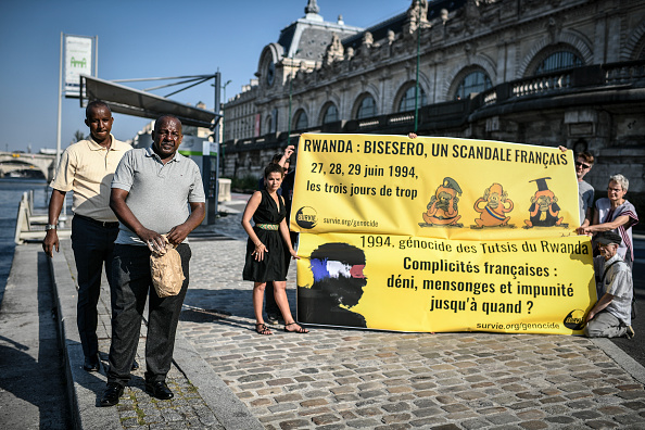 Les survivants tutsis du génocide rwandais du massacre de Bisesero posent avant de verser de la terre du terrain de Bisesero dans la Seine, le 26 juin 2019, à Paris. (STEPHANE DE SAKUTIN-/AFP via Getty Images)