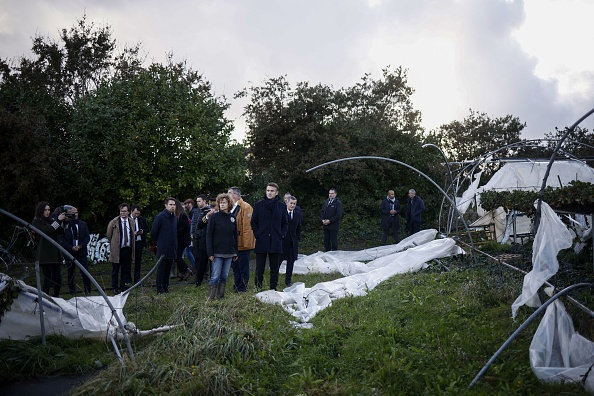 Le président français Emmanuel Macron (C) regarde les dégâts alors qu'il visite une ferme dans une région touchée par la tempête Ciaran à Plougastel-Daoulas, dans l'ouest de la France, le 3 novembre 2023.  (Photo YOAN VALAT/POOL/AFP via Getty Images)