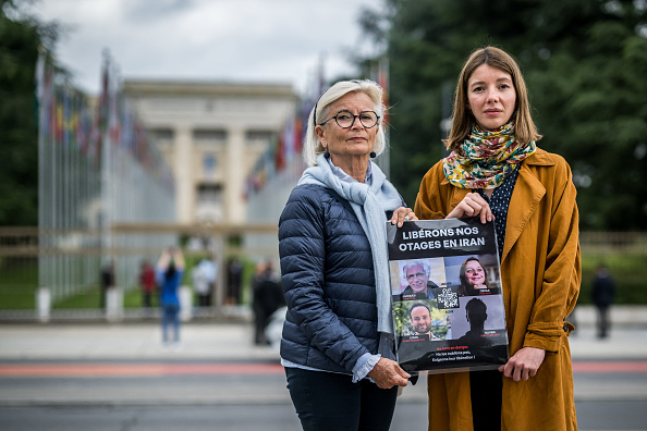 Sylvie Arnaud (à g.), mère de Louis Arnaud,  et Noémie Kohler, sœur de Cécile Kohler, deux proches des Français détenus en Iran posent devant les bureaux des Nations Unies à Genève, le 27 mai 2024. (FABRICE COFFRINI/AFP via Getty Images)