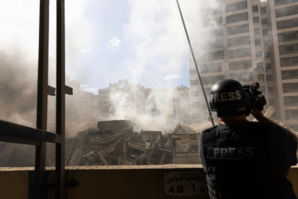 Un journaliste documente la destruction causée par une frappe aérienne israélienne, le 2 octobre 2024 à Beyrouth, au Liban. Illustration. (Daniel Carde/Getty Images)