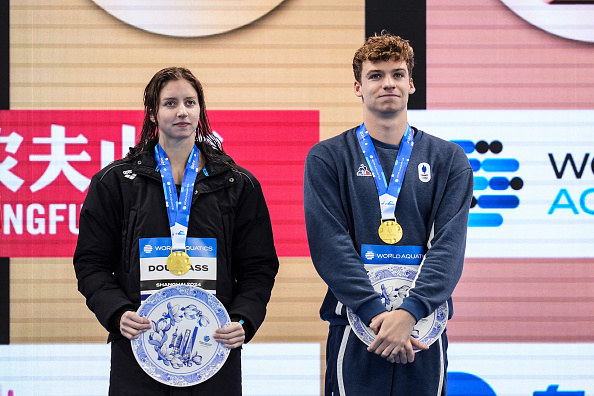 Les médaillés d'or Kate Douglas (USA) et Léon Marchand sur le podium lors d'une cérémonie de remise des trophées de la Coupe du monde de natation à l'Oriental Sports Centre Natatorium de Shanghai, le 20 octobre 2024. (Photo HECTOR RETAMAL/AFP via Getty Images)