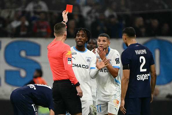 Paris bien supérieur aux Marseillais menait déjà 1-0 quand le milieu de terrain marseillais Amine Harit (2e à dr.) a reçu un carton rouge de l'arbitre François Letexier (à g.), annulant ainsi tous les espoirs marseillais de victoire, lors du match entre l'Olympique de Marseille (OM) et le Paris Saint-Germain (PSG) au Stade Vélodrome de Marseille, le 27 octobre 2024. (Photo CHRISTOPHE SIMON/AFP via Getty Images)