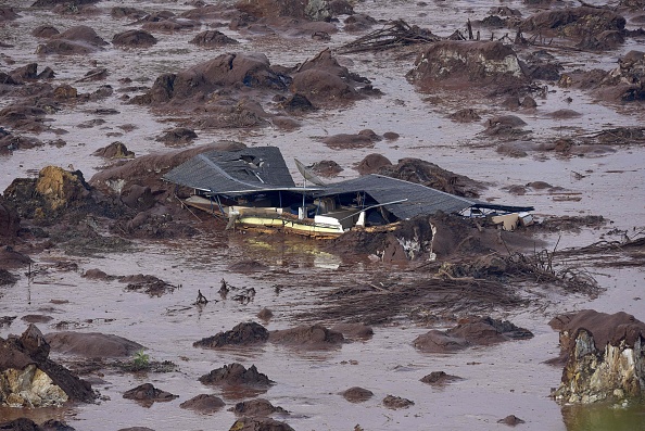 Vue générale de la rupture d'un barrage dans le village de Bento Rodrigues, à Mariana, dans l'État brésilien de Minas Gerais (sud-est), le 6 novembre 2015. Un barrage a rompu sur un site de déchets miniers, libérant un déluge de boue toxique rouge et épaisse qui a étouffé un village et tué au moins 17 personnes, a déclaré un responsable. La compagnie minière Samarco, qui exploite le site, est détenue conjointement par deux géants miniers, le brésilien Vale et l'australien BHP Billiton. (Photo DOUGLAS MAGNO/AFP via Getty Images) 