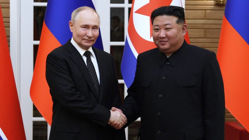 Le dirigeant nord-coréen Kim Jong Un (à dr.) et le président russe Vladimir Poutine se serrent la main après une cérémonie de bienvenue sur la place Kim Il Sung à Pyongyang, le 19 juin 2024. (GAVRIIL GRIGOROV/POOL/AFP via Getty Images)