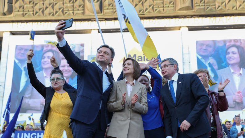 La présidente moldave et candidate à la réélection Maia Sandu (au c.) pose pour un selfie sur scène lors d'un rassemblement pour le lancement de sa campagne électorale à Chisinau, le 20 septembre 2024. (ELENA COVALENCO/AFP via Getty Images)