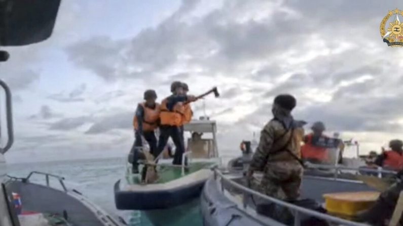 Des garde-côtes chinois brandissent des couteaux et des machettes alors qu'ils s'approchent des troupes philippines en mission de ravitaillement dans le Second Thomas Shoal, dans la mer de Chine méridionale contestée, le 17 juin 2024.  (Forces armées des Philippines)