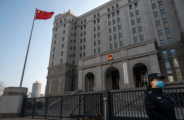 PÉKIN, CHINE : Un officier de police se tient à l'extérieur du tribunal populaire intermédiaire numéro 2 de Pékin. (Photo Kevin Frayer/Getty Images)