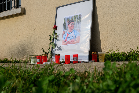 Des bougies et deux roses sont placées à côté d'un cadre avec une photo de Nicolas Dumas, en hommage au joueur de rugby du RCPP âgé de 22 ans, décédé des suites de ses blessures lors d'une fusillade le soir d'Halloween à la sortie de la discothèque Seven à St Peray en Ardèche. Le lieu de mémoire est situé aux abords du stade Donnadieu à Romans sur Isère, le 3 novembre 2024. (NICOLAS GUYONNET/Hans Lucas/AFP via Getty Images)