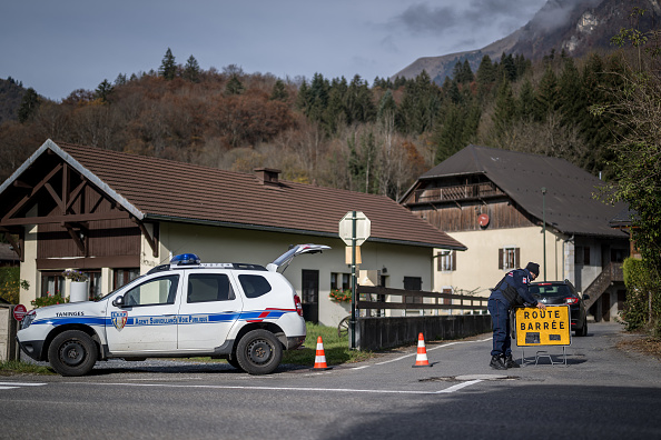 Un agent de surveillance ferme la route du hameau au-dessus de Taninges, dans les Alpes françaises, où trois enfants ont été retrouvés morts la veille, le 13 novembre 2024. (FABRICE COFFRINI/AFP via Getty Images)