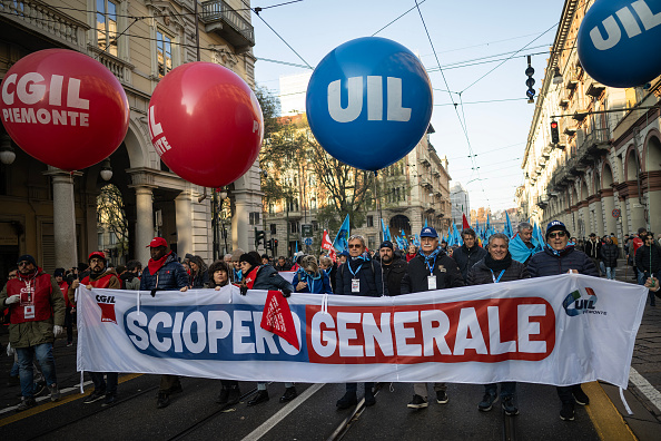 Des manifestants portent une banderole portant l'inscription « Grève générale » lors d'une manifestation contre la réduction des heures de grève, le 29 novembre 2024. (MARCO BERTORELLO/AFP via Getty Images)